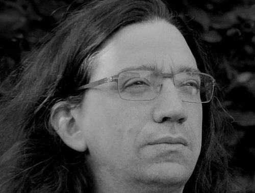Curtis Yarvin – Dark Enlightenment Movement Leader and Primary Theorist Curtis Yarvin, leader of the Dark Enlightenment or Neo-Reactionary Movement, in a black and white portrait photograph